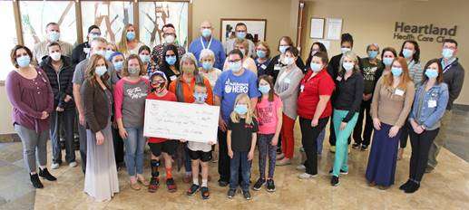 <i><b>Pictured in front holding the check are Ethan (left) and his brother, Joshua. Just behind them is more of Ethan’s family, including his mother Heather (to Ethan’s right), and to her left are Ethan’s Grandmother Debbie Jenne, Aunt Katie Jenne, and cousins Maddilyn Jenne and Makayla Jenne. Standing behind the family are just a few of the many MHS employees who support Ethan and his family in their journey.</b> Photo courtesy MHS</i>