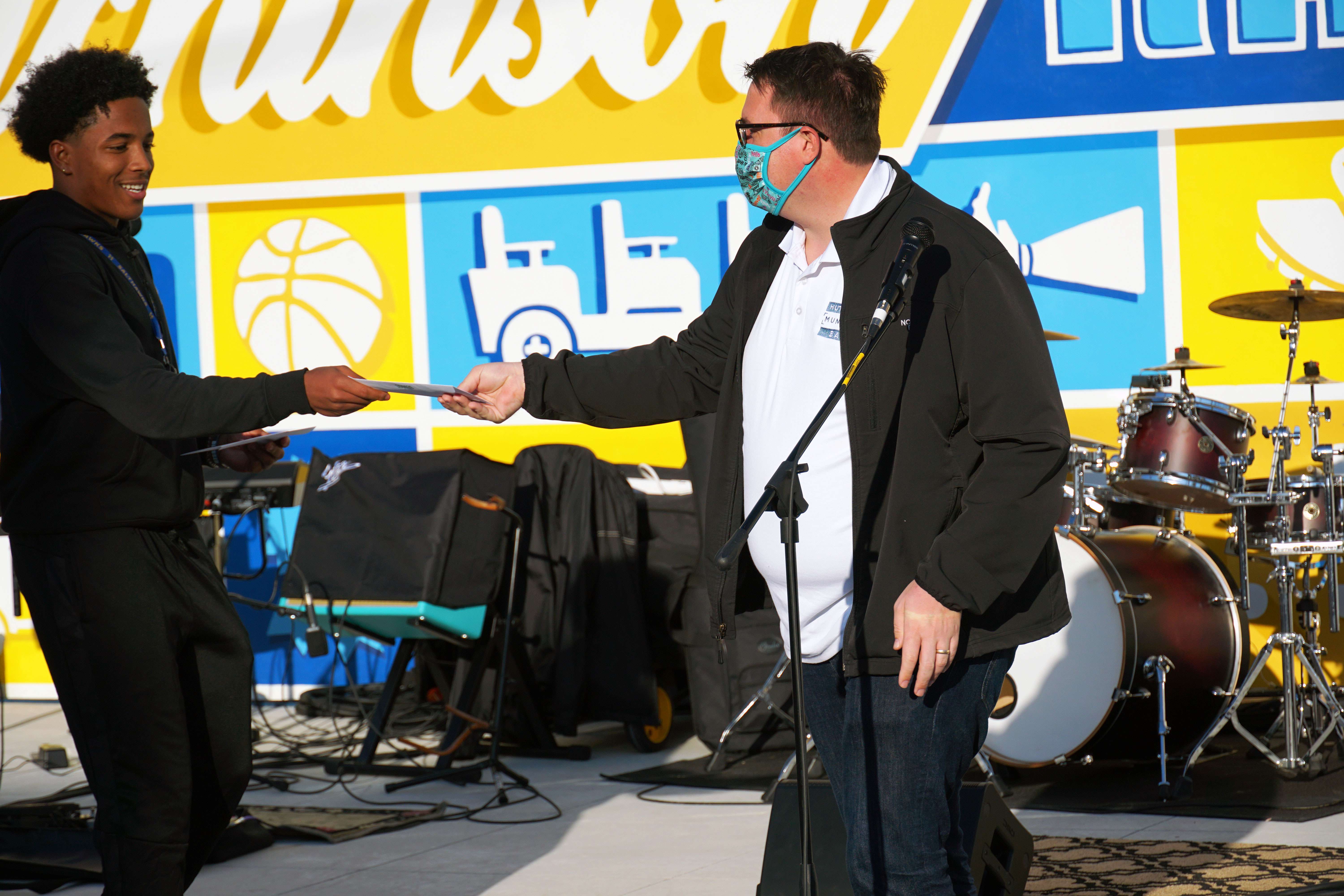 Changemakers at Work Grants Committee member Stephfon Hunter hands a grant check to Hutchinson Municipal Band representative Charles Johnston at the Changemakers at Work Grant Awards program Thursday evening at Chester I. Lewis Plaza. [Courtesy of Hutchinson Community Foundation]