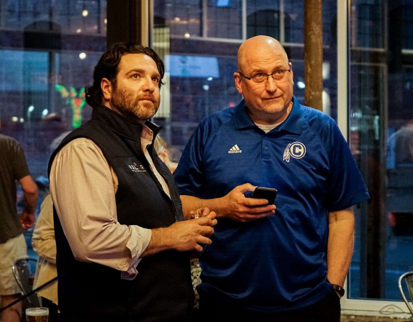 School Board Vice President Lute Atieh and community member Mike Moore watch as election returns come in / Photo by Whitnee Ice