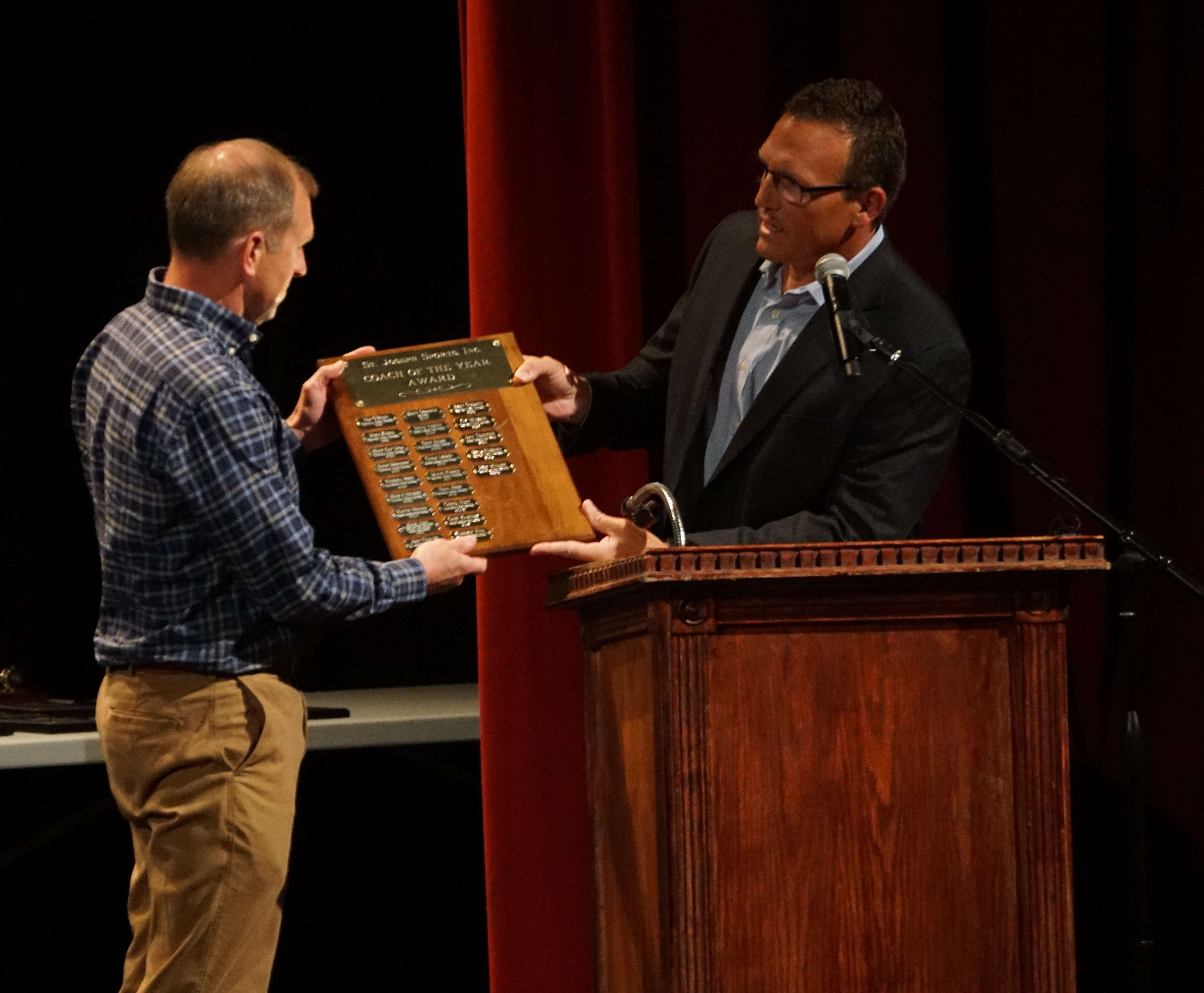 St. Joseph Central Cross Country coach Bob Miller accepts the Coach of the Year traveling plaque from Dr. Brett Miller at Wednesday's St. Joseph Scholar Athlete ceremony at the Missouri Theater on Wednesday evening. Photo by Tommy Rezac.