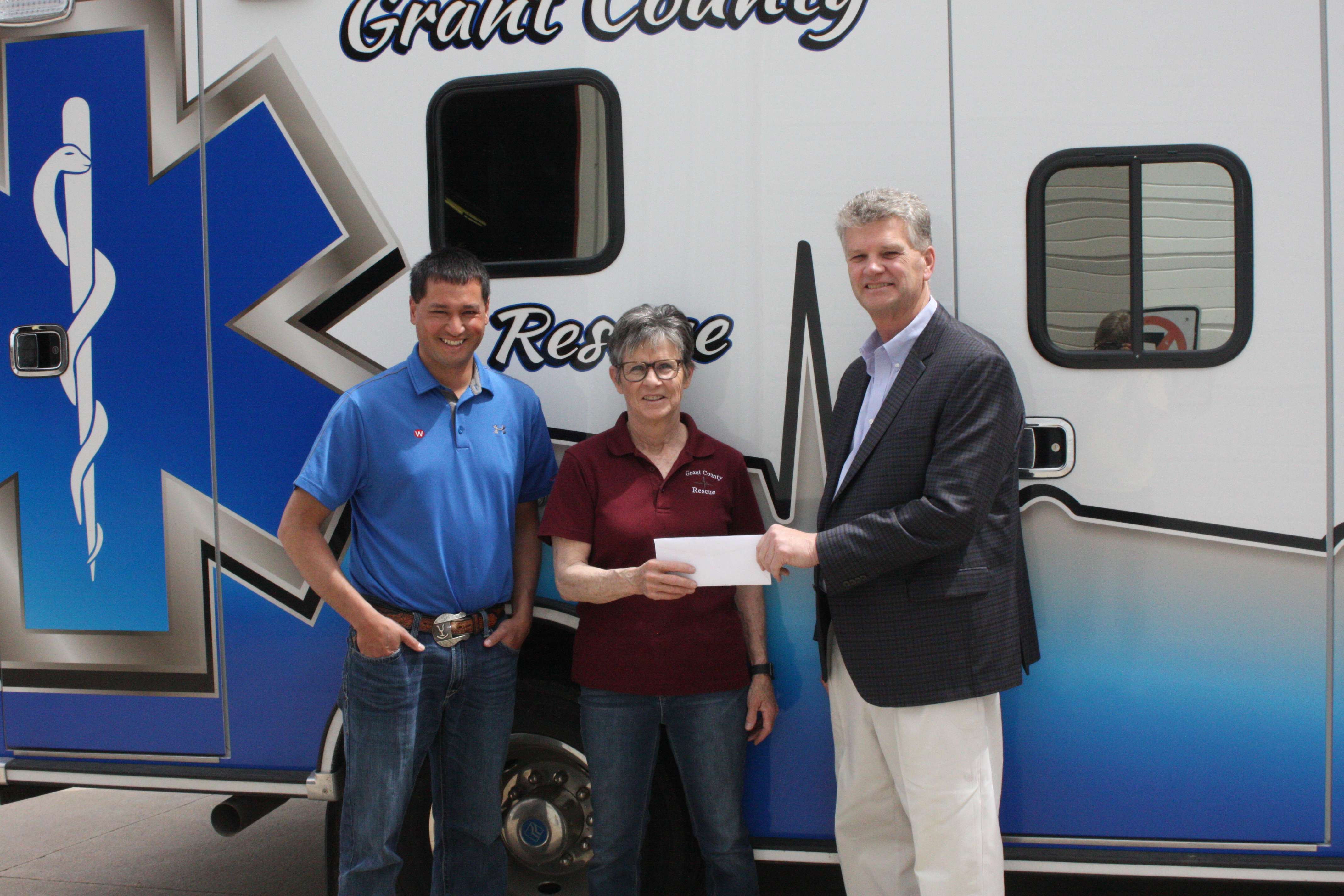 WESTCO Feed Division Manager, Jared Mracek, (left) and WESTCO CEO David Briggs (right) present Nancy Edelman of Grant County Rescue Service with checks totaling $10,000 for the new GCRS ambulance. Funds were made possible by the CHS Seeds of Stewardship matching grant program. Photo courtesy of Kayla Wintz