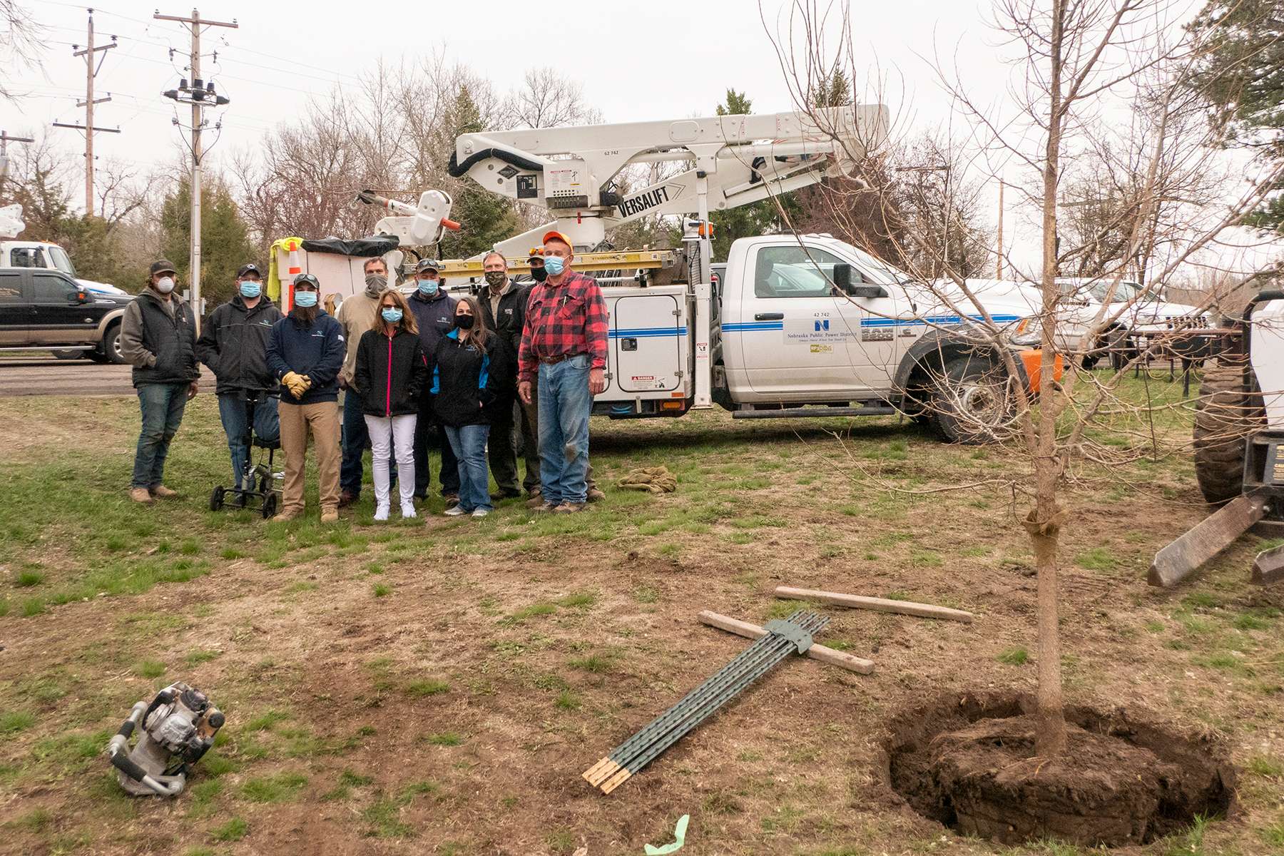 A group of Chadron State Park and Nebraska Public Power District employees pose near one of the nine trees planted on Tuesday.&nbsp;