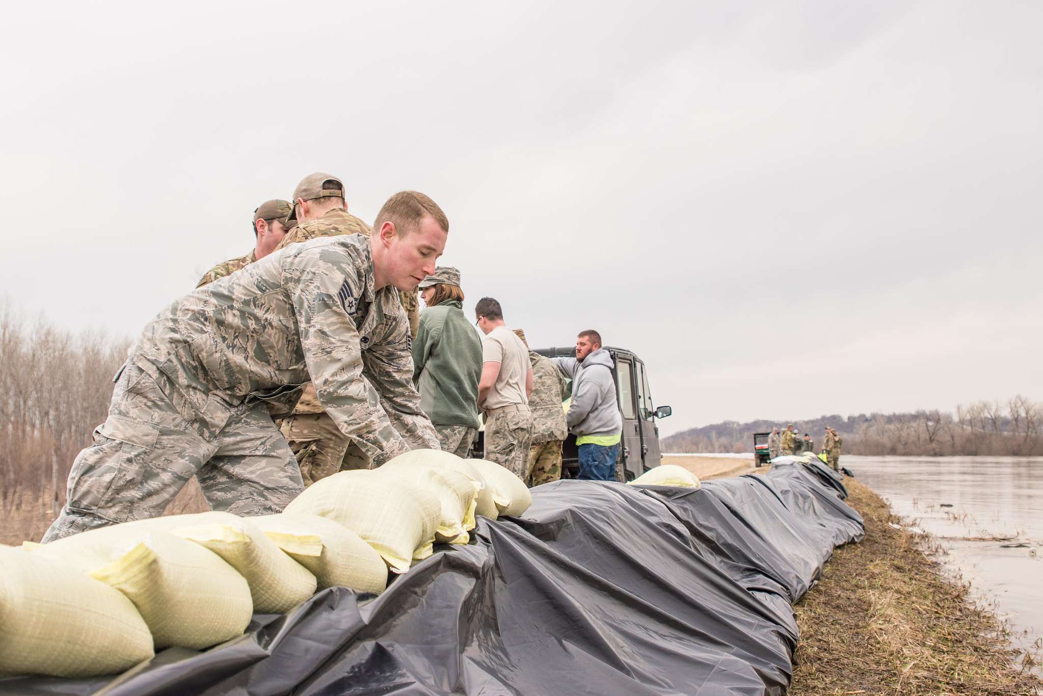 Members of the Air National Guard 139th Airlift Group pile sandbags on the Missouri River levee protecting Elwood, Kansas and Rosecrans Memorial Airport/Photo courtesy of the 139th Airlift Group