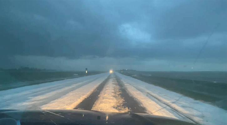 Hail blankets the roadway six miles north of Grant on Saturday evening. Photo: Russ and Davon DaMoude (Facebook)