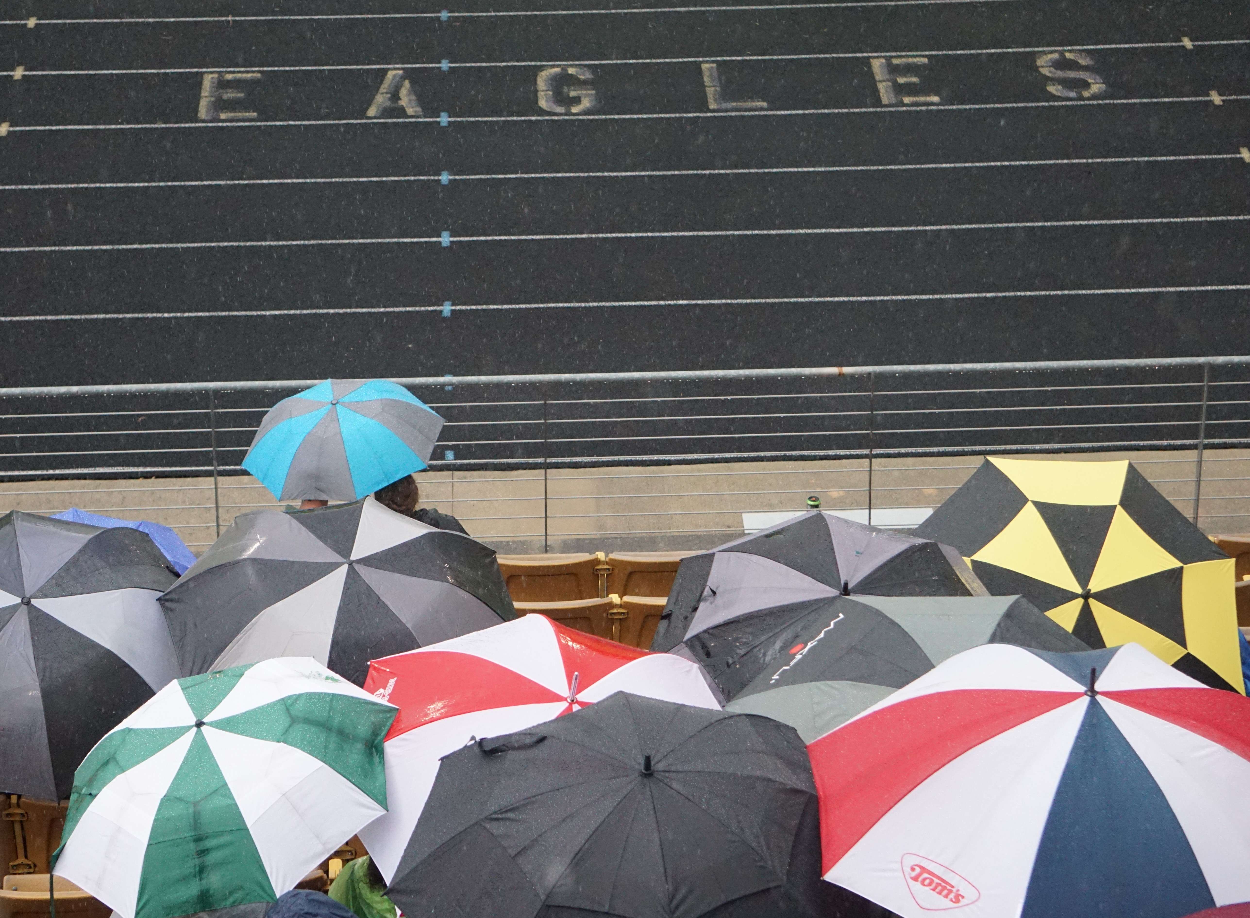 Fans break out their umbrellas during the first half at Eagle Stadium.