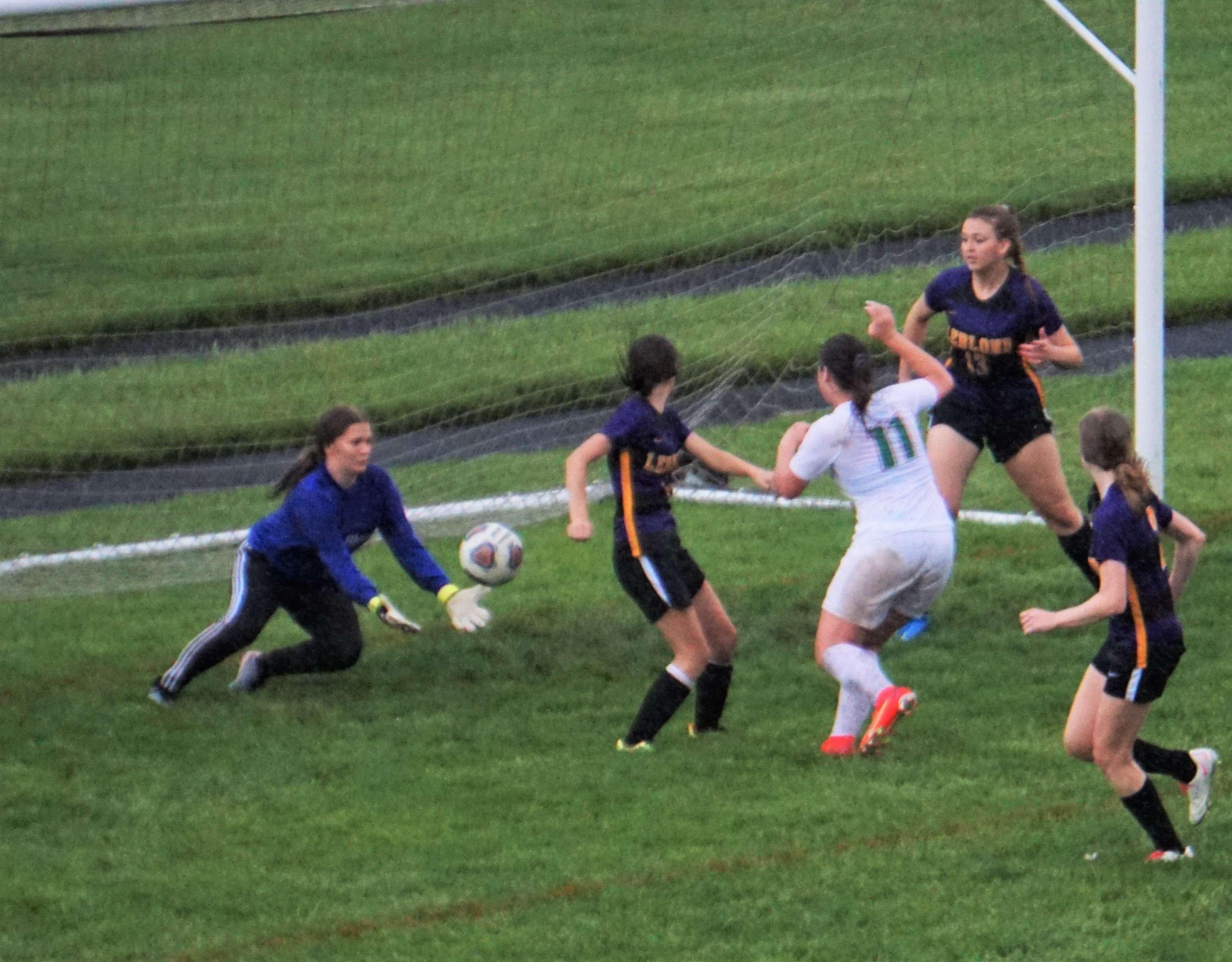 LeBlond's Hannah Bentrup (blue) defends a shot-on-goal from Mid-Buchanan's Layson Hafley (11). Photo by Tommy Rezac.