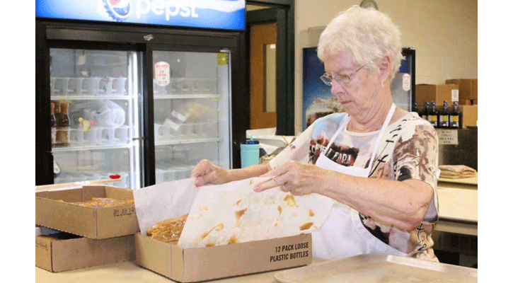<i>Volunteer Doris Howard prepares cinnamon rolls for the 2019 Sweet Saloon. This year’s fundraiser will begin accepting pre-orders June 8.</i>