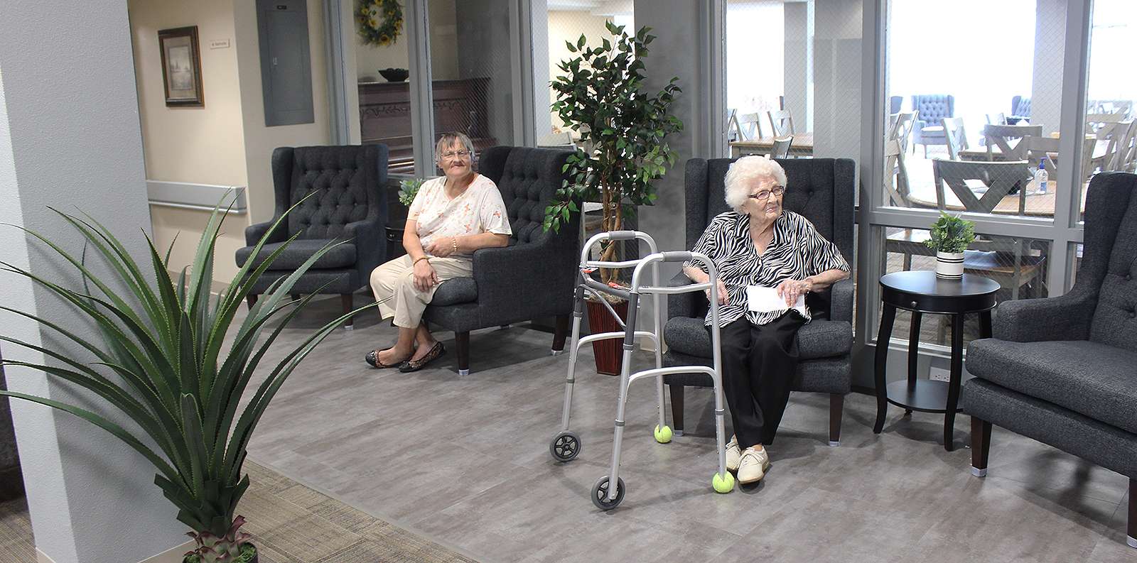 Two Epworth Towers residents relax in the renovated lobby of the income-based apartments in Hays. Photo by Cristina Janney/Hays Post