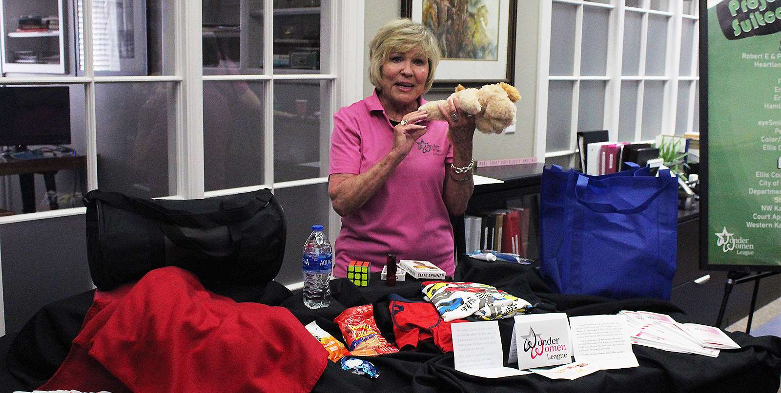 Wonder Women League co-chairwoman Nancy Jeter holds up a stuffed animal, which is an example of what is in the duffle bags given to foster children as part of the league's Project Suitcase.