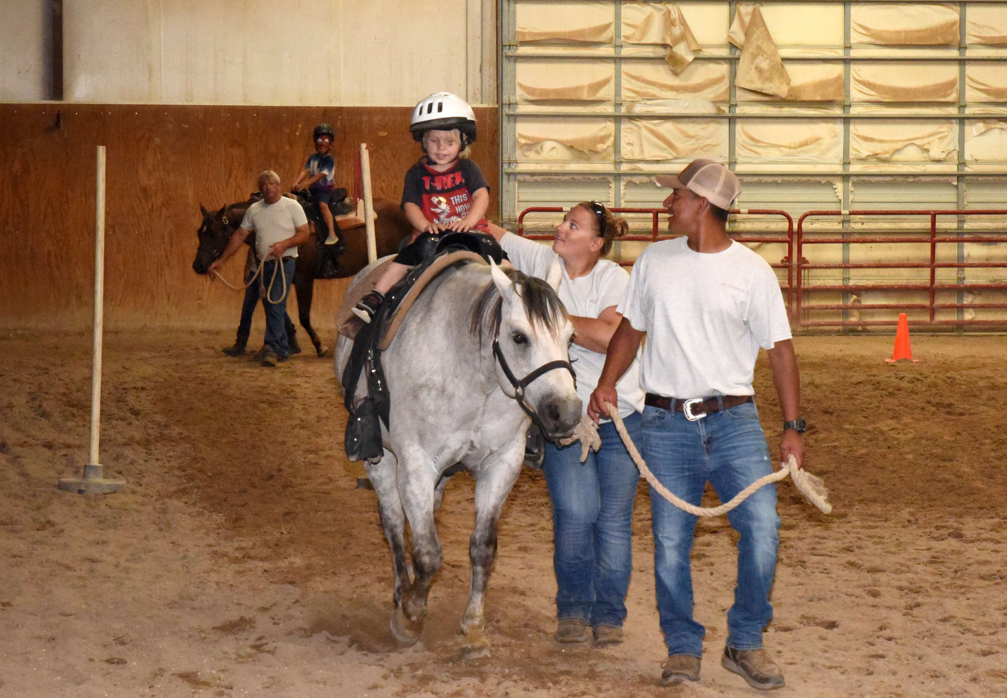 Young horse riders enjoy trail riding during Kids Day on June 12. Leading “Cash” in the foreground are equine riding instructors Juan Bodine and Tandy Webb. In the background leading “Jordan” is Rosewood Ranch Manager Eric Hammond.