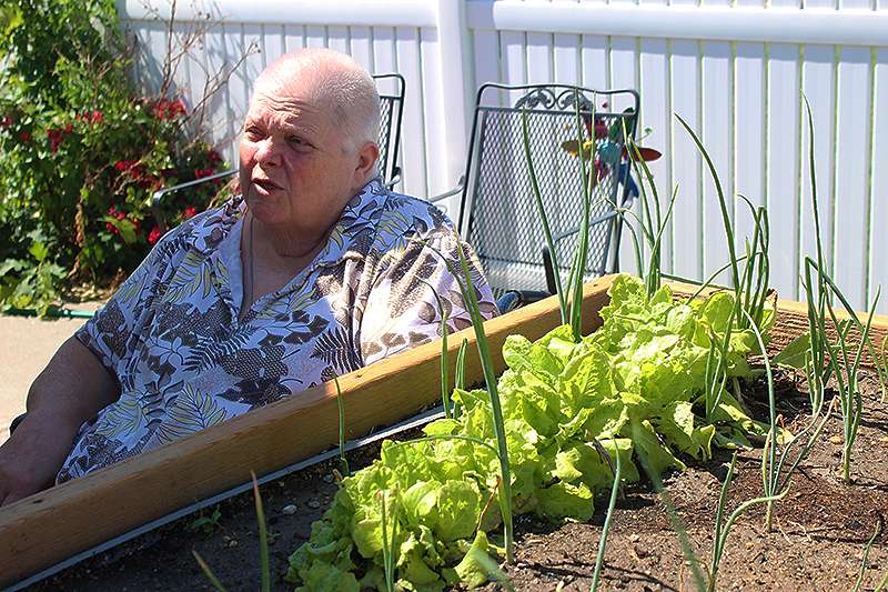 Frankie Ream, Good Samaritan Society resident, sits next to one of the newly donated raised garden beds. The beds were elevated to make it easier for residents in wheelchairs to work in them.&nbsp;Cristina Janney/Hays Post