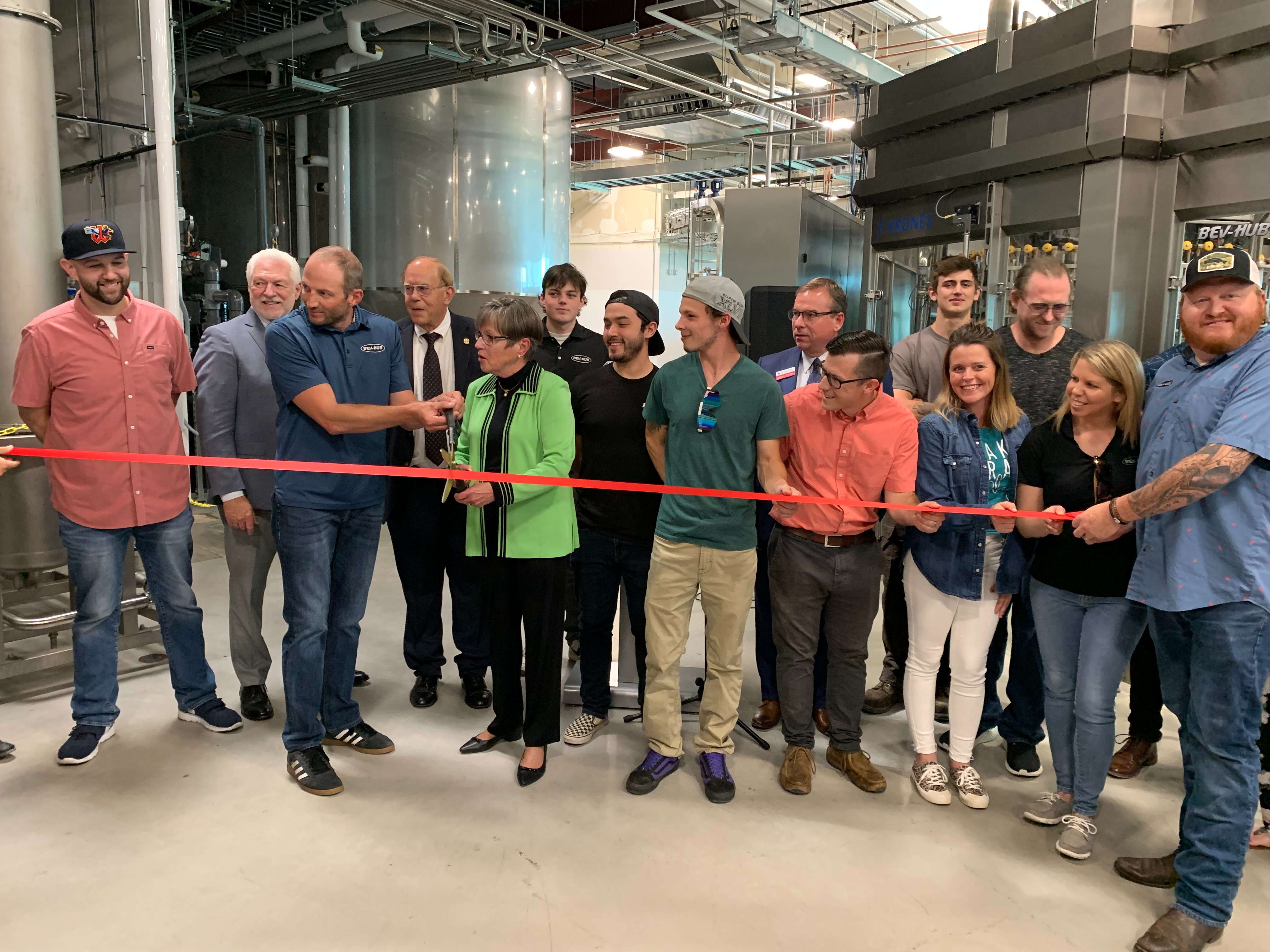 Dan McDonald, Kansas Governor Laura Kelly, and other key members of Bev-Hub's team celebrate the ribbon cutting at its new facility in Manhattan.