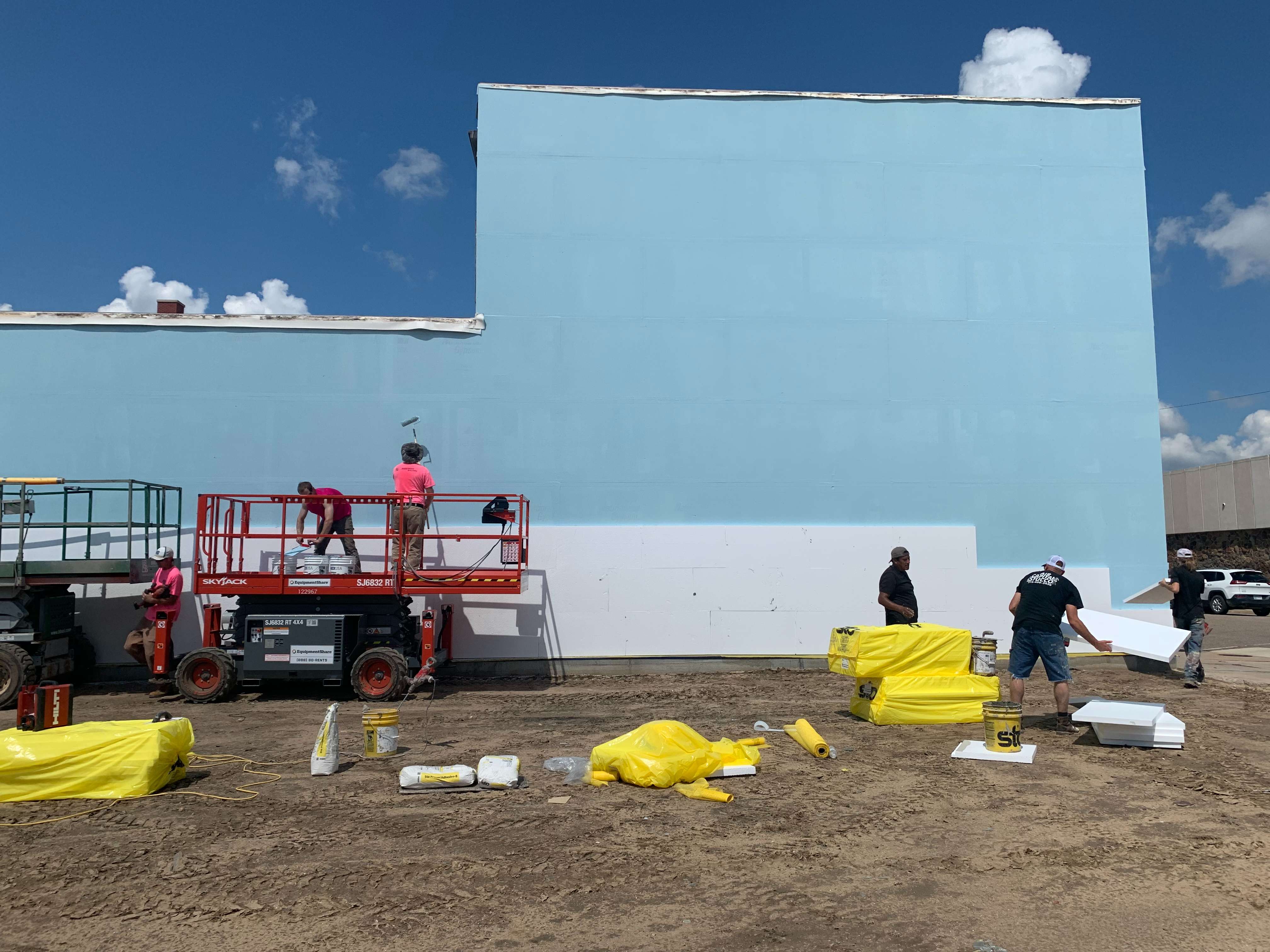 A crew from Brentwood Builders prepares the east wall of the building near the Forest &amp; Williams intersection in Great Bend for a mural to be painted.