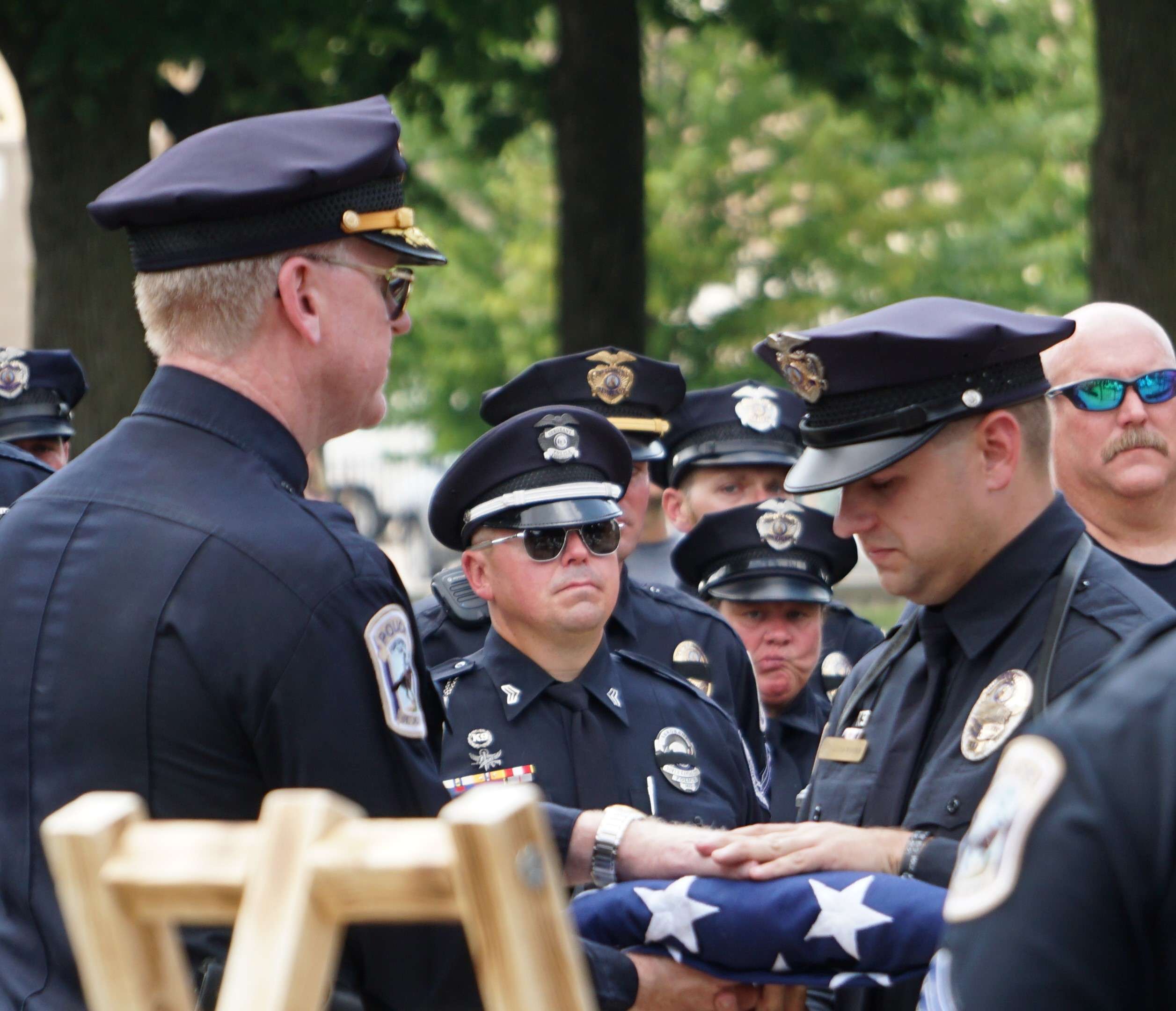 K-9 Max's handler, officer Lucas Winder (right), receives a folded American flag from St. Joseph Police Chief Chris Connally (right) during Friday's farewell service. Photo by Tommy Rezac.