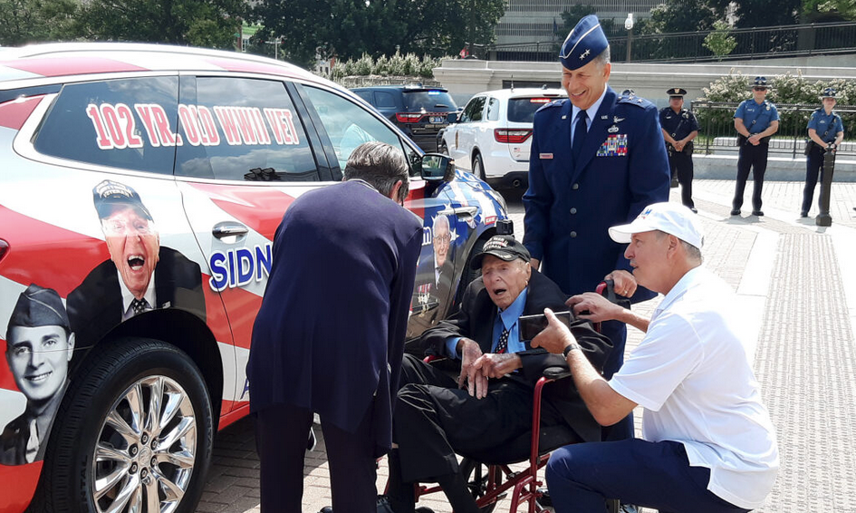 World War II veteran Sidney Walton, 102, met Tuesday with Gov. Laura Kelly at the Capitol during a 50-state tour to raise awareness and financial support for veterans and frontline nurses. Kelly presented him with a Kansas flag. (Tim Carpenter/Kansas Reflector)