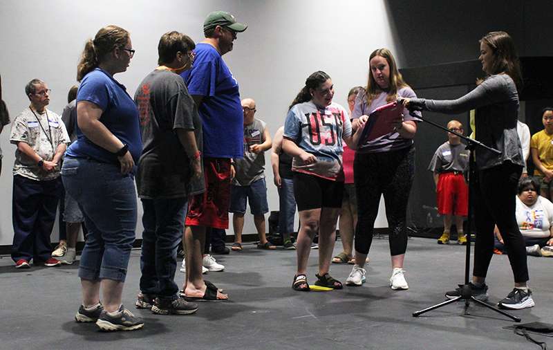 A Center Stage Theatre Camp actress, center, uses an assistive device, which speaks her line.