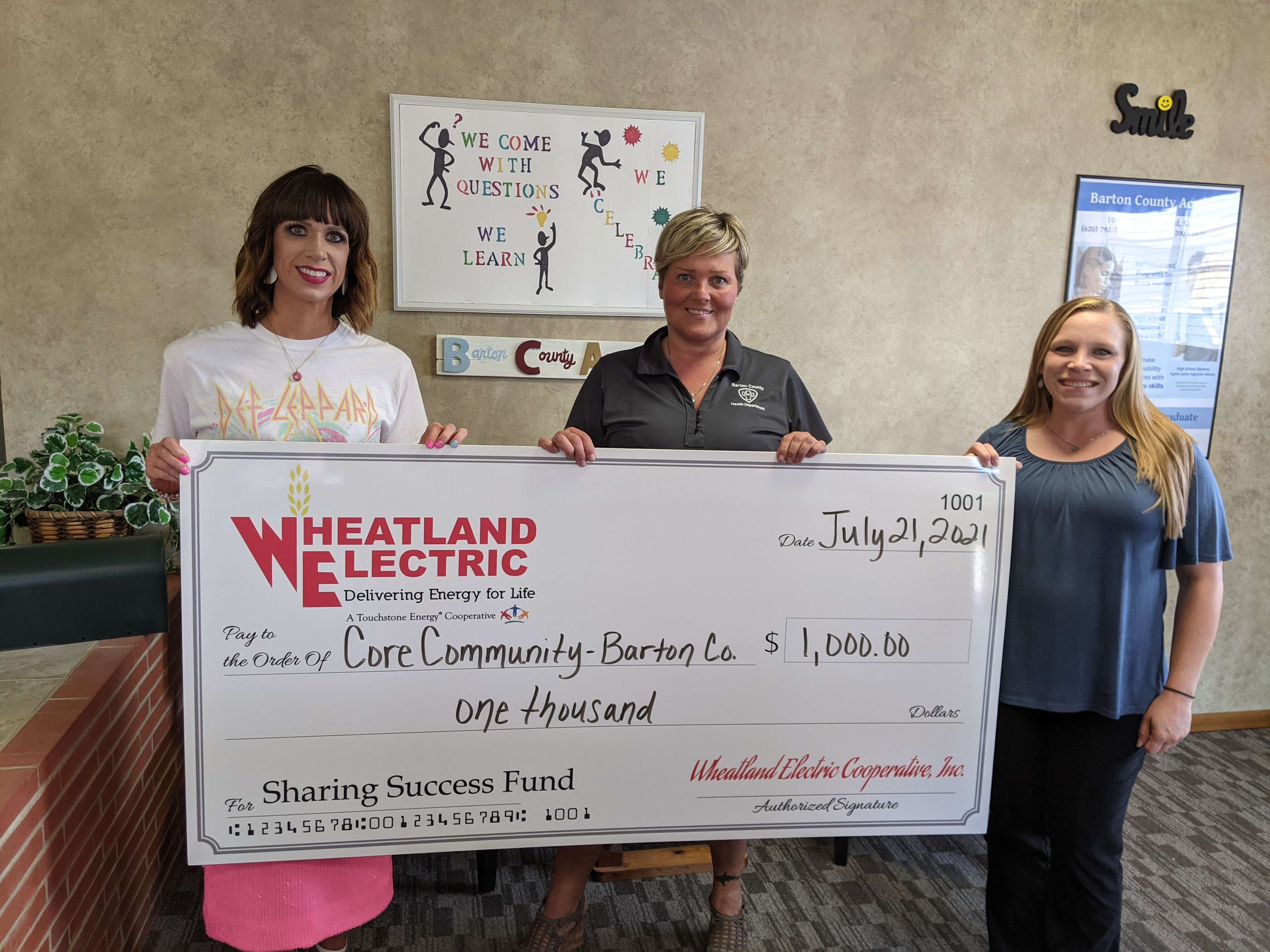 Alli Conine (left), manager of member services &amp; corporate communications for Wheatland Electric, presents a $1,000 Sharing Success grant to Amy Ferguson, (center), advisory board member, and Amanda Howard (right), community coordinator for the Core Community program in Barton County, at the Barton County Academy.