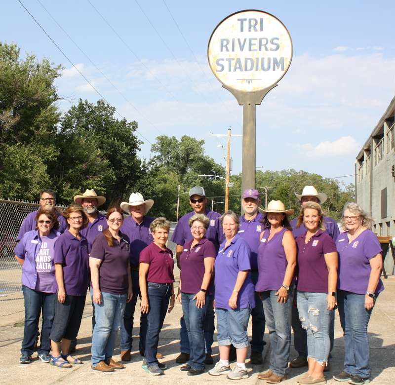 <b>Members of the fair board gathered in front of the Tr-Rivers Stadium sign on Aug. 7, the last full day of the Tri-Rivers Fair. The are,
back row from left: Rex Lacy, Ron Kinkelaar, Ken Wasserman, Chris Rost, Carl Garten, and Eric Blomquist; front row from left: Linda Lecklider, Denise Stein, Melissa Theel, Nancy Paugh, Kim Norwood, Abbe Hicks, Linda Lilly, Amber Fouard, and Kathy White.</b> Salina Post photo