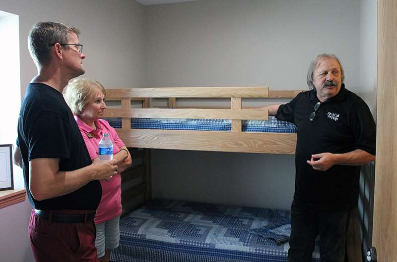 Dennis Wilson, First Call for Help board member, discusses the new First Step Housing Project, with Shuan Musil, city commissioner, and Marie Froelich, Wonder Women League. The three are standing in one of the project's bedrooms. The project can accommodate eight to 12 people.