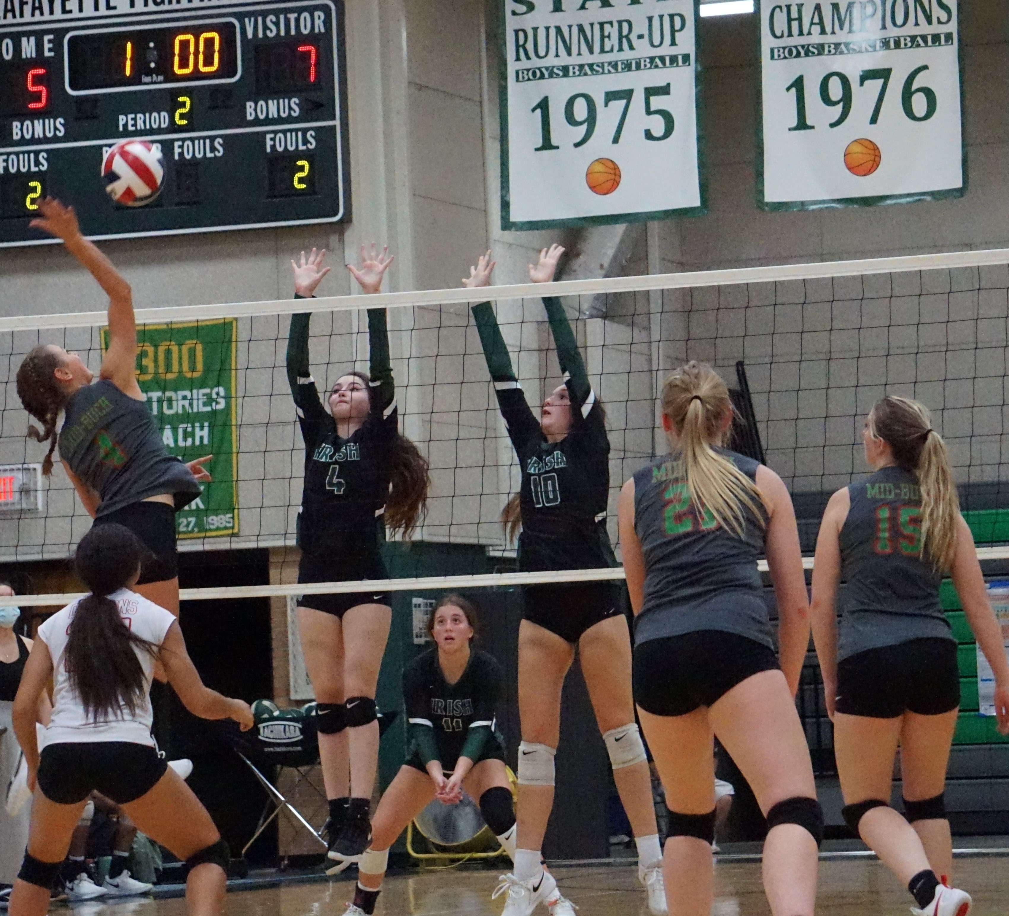 Liv Moeckl (left) tries to hit a ball past Lafayette's Modesta Wilhelmson (4) and Remi Vandever (10).