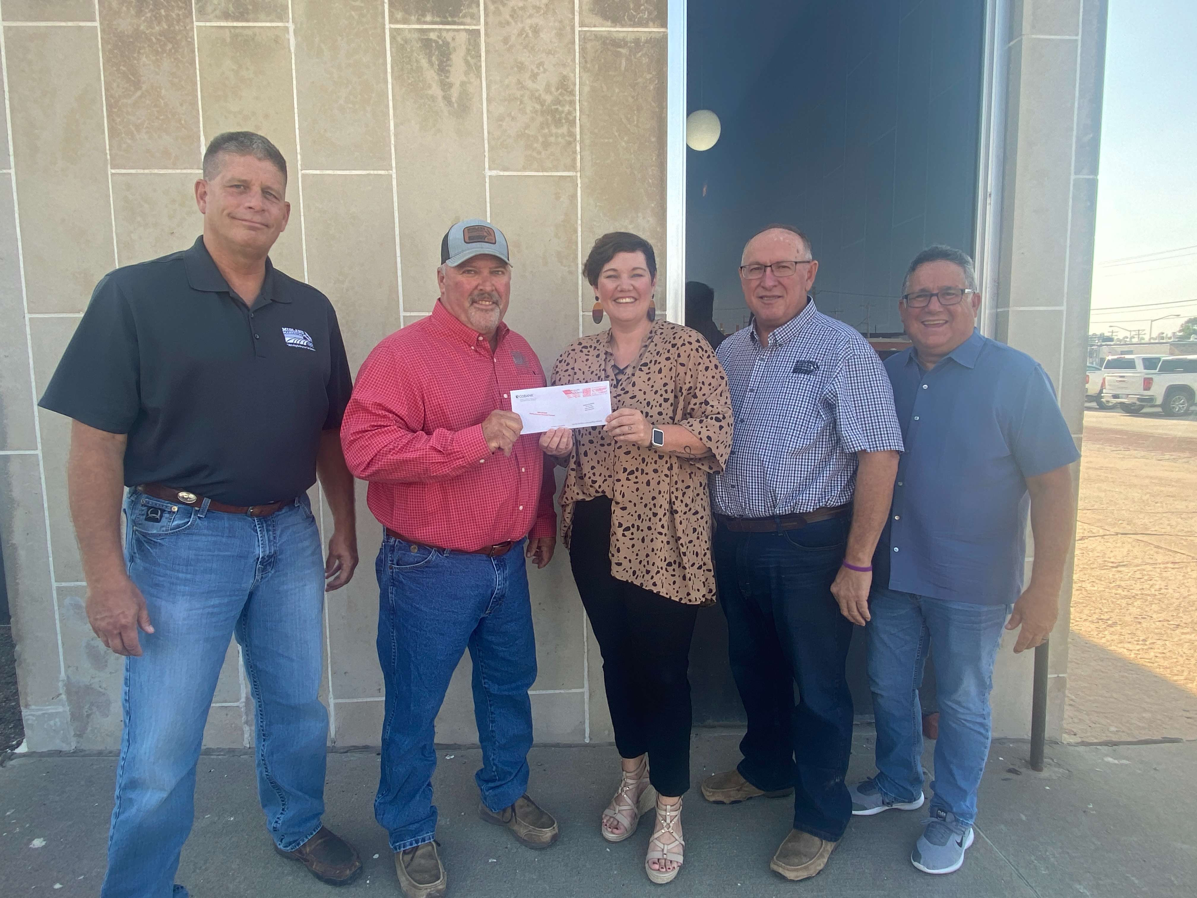 From left to right: Kevin Royer, Midland Marketing general manager, Brian Staab, Midland Marketing board president, Sara Bloom, Downtown Hays Development Corporation Executive Director, Tom Benoit, Midland Marketing board member, and Dennis Schiel, Hays artist. Midland Marketing recently donated $20,000 to the Brush the Bricks Mural Movement in Downtown Hays.