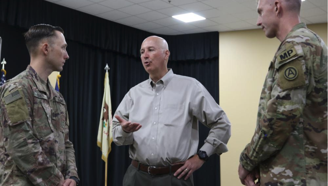 Gov. Pete Ricketts talks to Capt. Jared L. Baker, left, outgoing commander of the 1057th Military Police Company and Capt. Grant J. Hewitt, the inbound commander of the 1057th, during a visit to Kuwait earlier this year for a change of command ceremony. (Courtesy of Nebraska National Guard Capt. Brittney Truscott)