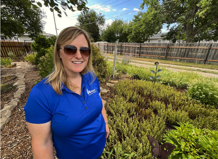 Hays water conservation specialist Holly Dickman stands in a yard that won the town's conservation award a couple of years ago. It shows an example of using drought-tolerant plants to replace grass. David Condos / Kansas News Service