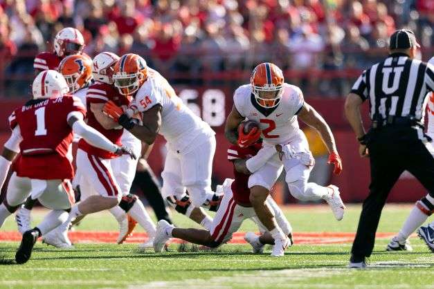 Illinois' Chase Brown (2) rushes as Nebraska's Myles Farmer (8) grabs him from behind during the first half of an NCAA college football game Saturday, Oct. 29, 2022, in Lincoln, Neb. (AP Photo/Rebecca S. Gratz)