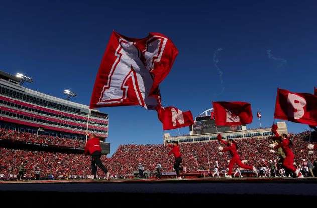 Nebraska cheerleaders celebrate a touchdown against Minnesota during the first half of an NCAA college football game Saturday, Nov. 5, 2022, in Lincoln, Neb. College athletic programs are reacting to soaring inflation the same way as everyone else — they’re looking for ways big and small to save money. (AP Photo/Rebecca S. Gratz)