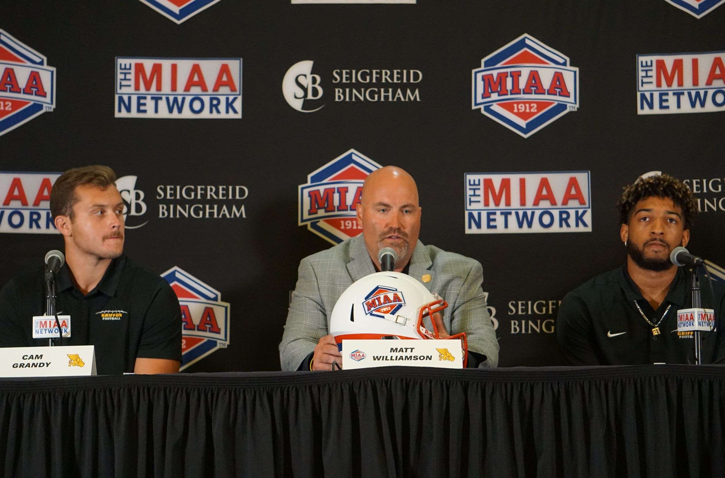 Williamson (center) with tight end Cam Grandy (left) and cornerback D.J. Stirgus (right) at MIAA Media Day in 2022. Stock photo by Tommy Rezac.