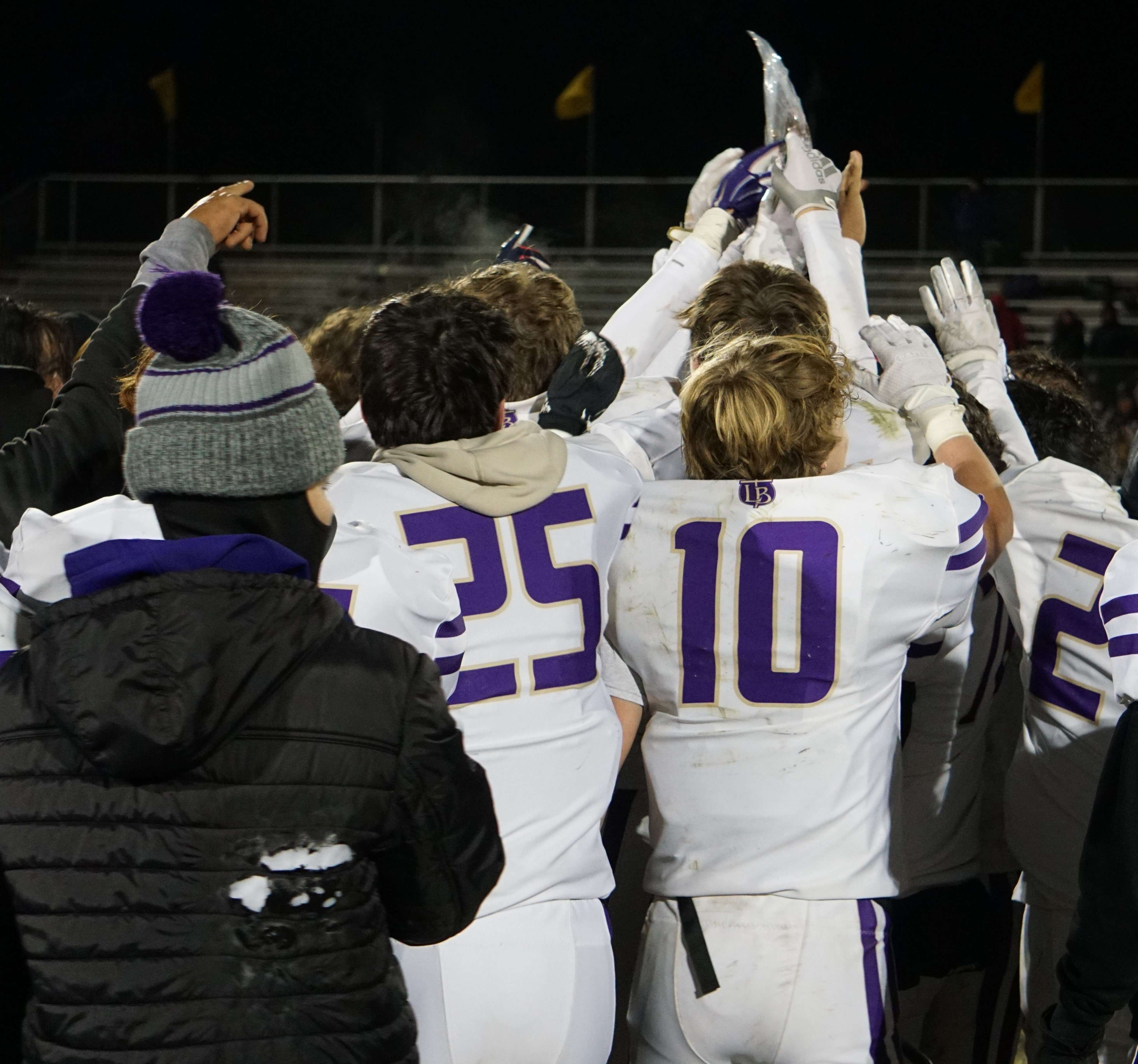 Members of the Bishop LeBlond football team hoist the district title plaque after a 50-38 win at Orrick.