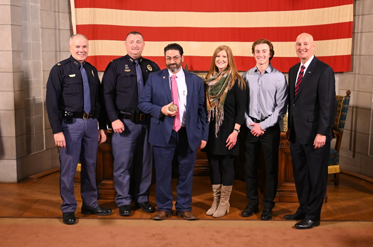 From left to right: Col. Bolduc, Lt. Stahl, Frank Axiotes, Shelley Axiotes, Zack Axiotes, and Governor Ricketts