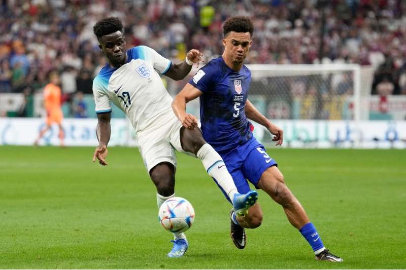 <b>Antonee Robinson of the United States vies for the ball with England's Bukayo Saka, left, during the World Cup group B soccer match at the Al Bayt Stadium in Al Khor, Qatar, Friday.</b> (AP Photo/Luca Bruno)