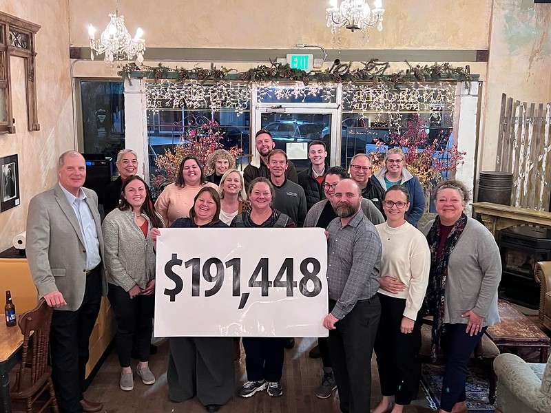 The Chadron State Foundation Fall Fund Drive community and campus volunteers pose at the Bean Broker Nov. 17, 2022, with a banner displaying the total amount pledged during the drive. (courtesy photo, used with permission)