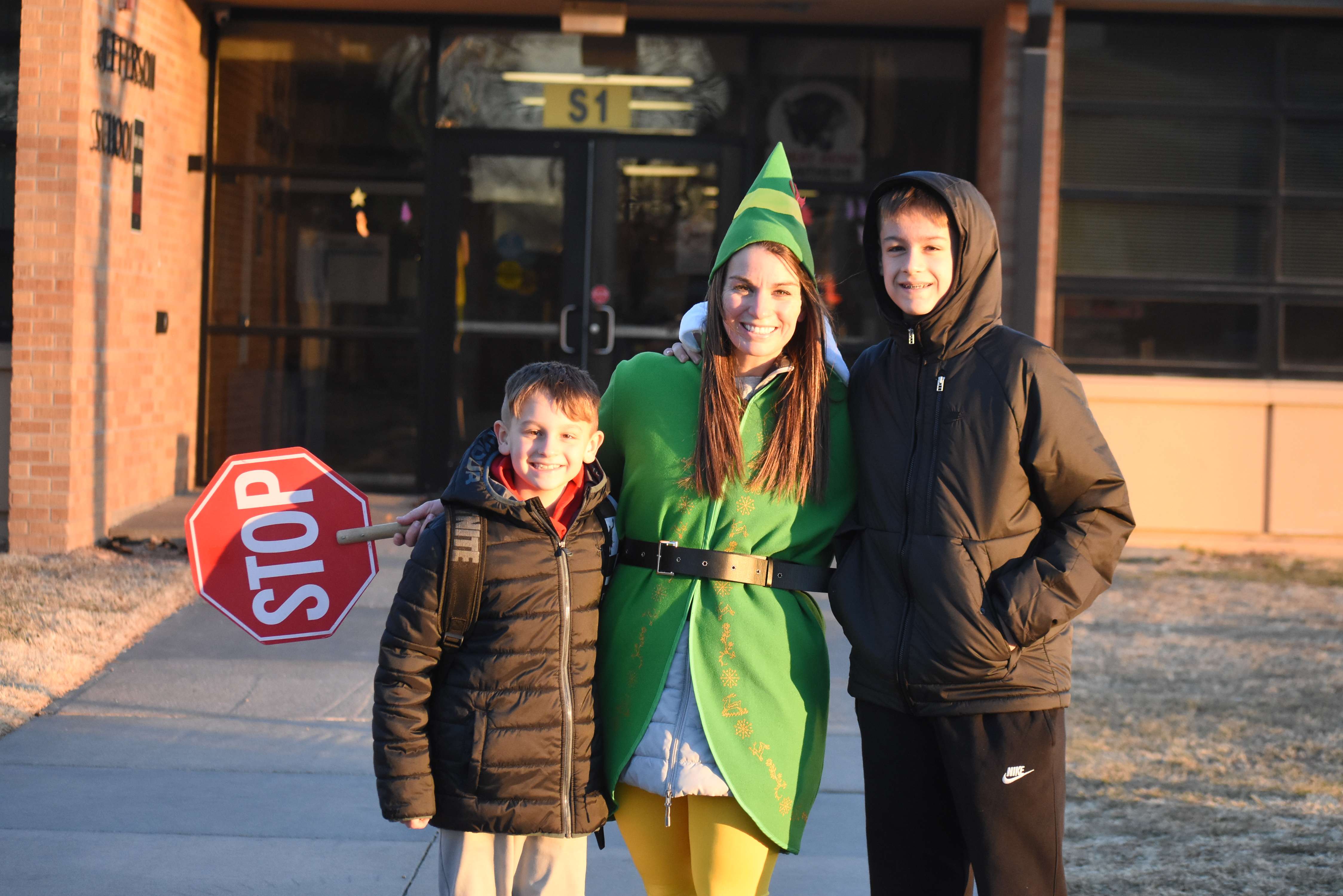 Jefferson Elementary School Technology Coach Abby Jonas, seen here with students Cooper and Carter Dreiling, makes crossing the street fun during the holiday season.