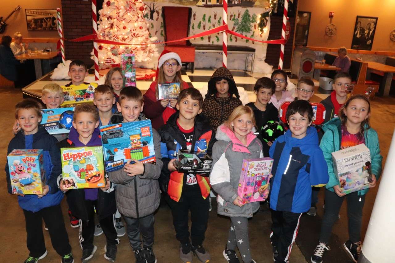 Students in Amy Mayo's third-grade class at Roosevelt Elementary School hold up toys they bought for the Toys for Tots program with proceeds from a fundraiser. Courtesy photo<br>