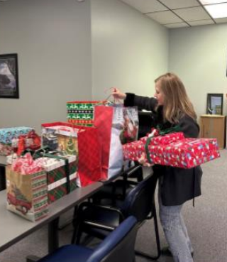 Mary Hoisington, member services and key accounts manager, helps deliver gifts to the Saint Francis Ministries office in Great Bend