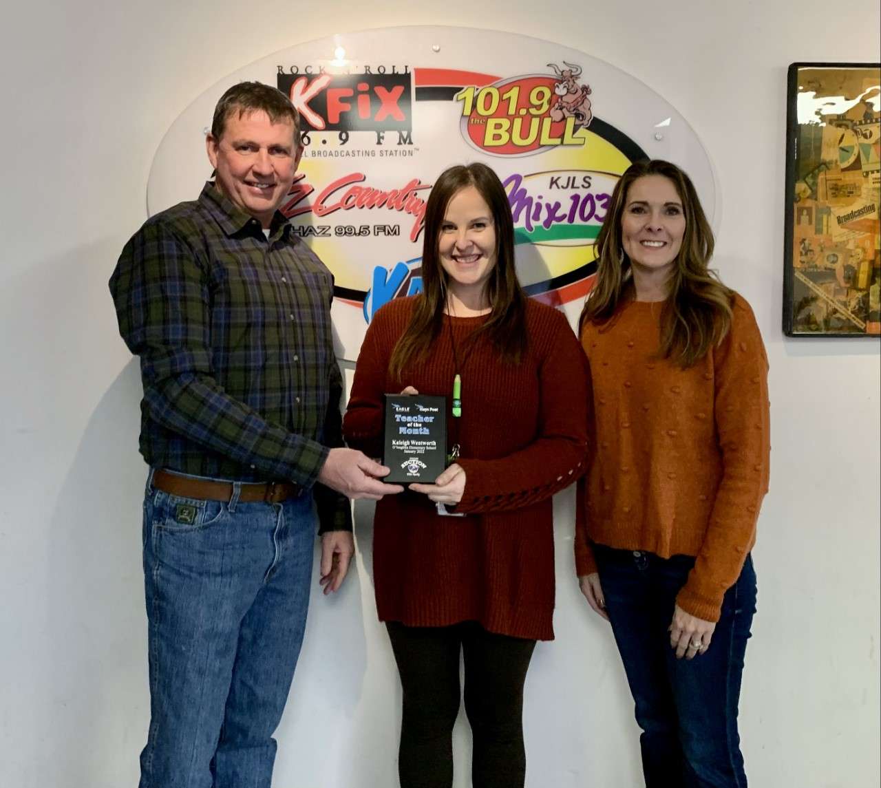 Mark  and Lynette Ottley of Nations Auction Elite Realty present Kaleigh Wentworth, second -and third-grade teacher at O'Loughlin Elementary School, with the January Teacher of the Month award.
