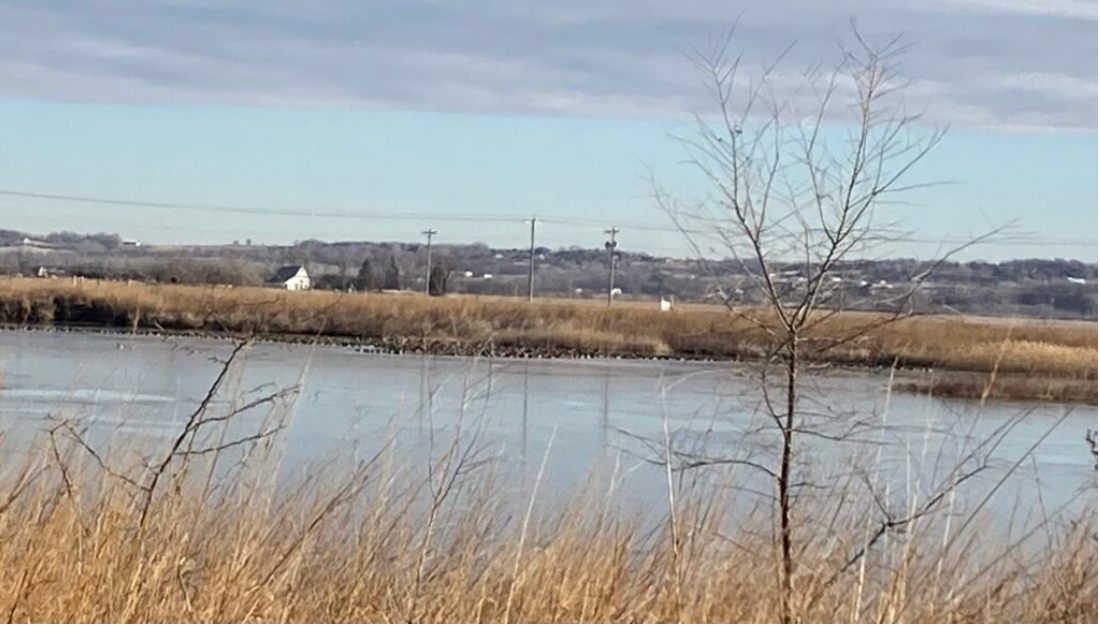 The site of a big lake for recreation, proposed by state legislators, already has a handful of sandpits and sits just west of Gretna, which is visible on the bluff in the distance. (Paul Hammel/Nebraska Examiner)
