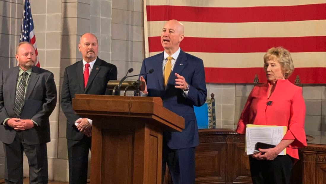 Gov. Pete Ricketts, behind podium, was joined by, from left, Tom Riley, director of the Nebraska Department of Natural Resources; prisons director Scott Frakes; and State Sen. Lou Ann Linehan. (Paul Hammel/Nebraska Examiner)