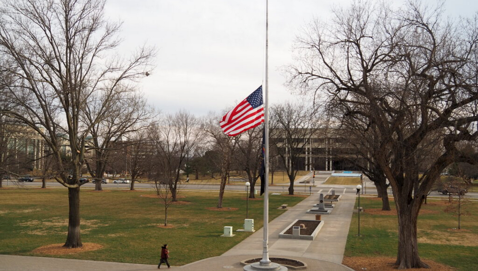The flag is lowered Wednesday in front of the Kansas Judicial Center in Topeka to recognize the 8,000 Kansans who have died from COVID-19. (Tim Carpenter/Kansas Reflector)