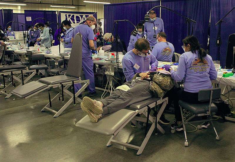 Dental professionals work on patients Friday during the Kansas Mission of Mercy free dental clinic at the Ellis County Fairgrounds in Hays. Photo by Cristina Janney / Hays Post<br>