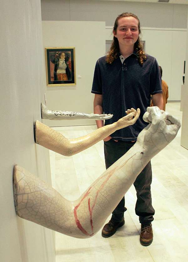 Mason Lane Cloud, junior in ceramics from Wichita, with his ceramic piece "Outreach." The piece explores self-harm. Photo by Cristina Janney/Hays Post