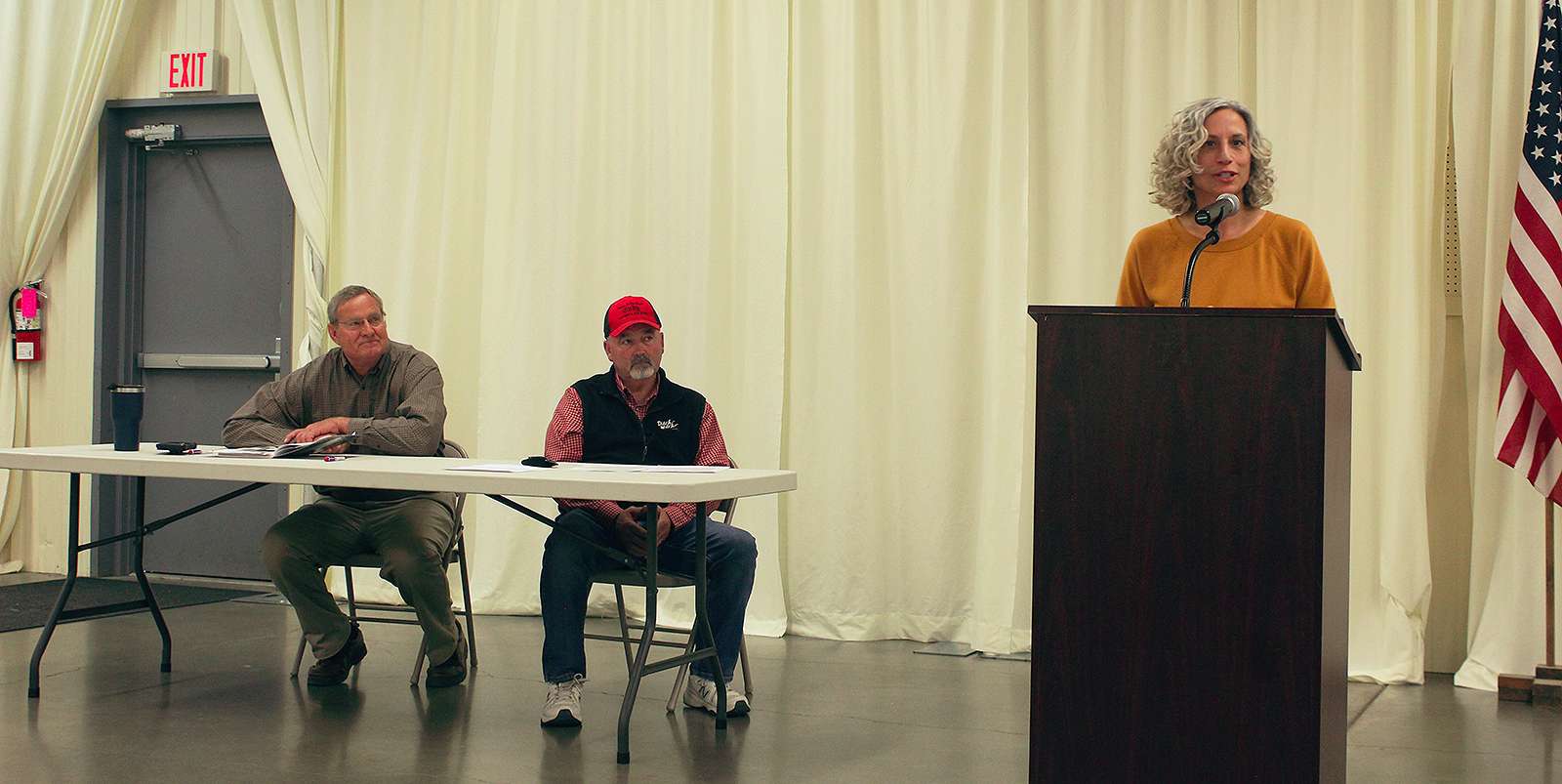 Cathy Hopkins, past USD 489 school board candidate, speaks to a group on the school bond on Tuesday. From left, Joe Wilkerson and Neal Younger, Ellis County commissioner, look on. Photo Cristina Janney / Hays Post<br>