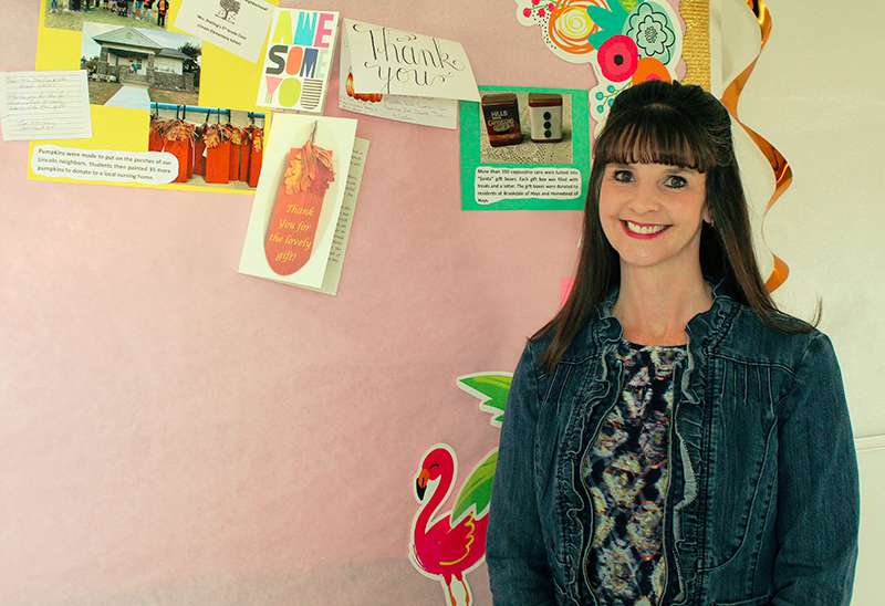 Monica Dreiling, a fifth-grade teacher at Lincoln Elementary School, was named the Hays Post Teacher of the Month for April. She is pictured with photos and thank you notes associated with her class's community service projects. Photo by Cristina Janney / Hays Post<br>