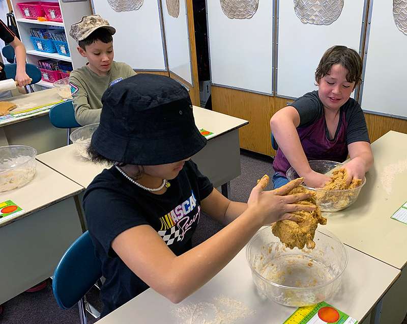 Students in Monica Dreiling's fifth-grade class at Lincoln Elementary School make dog treats for the Humane Society as a class community service project earlier this school year. Courtesy photo<br>