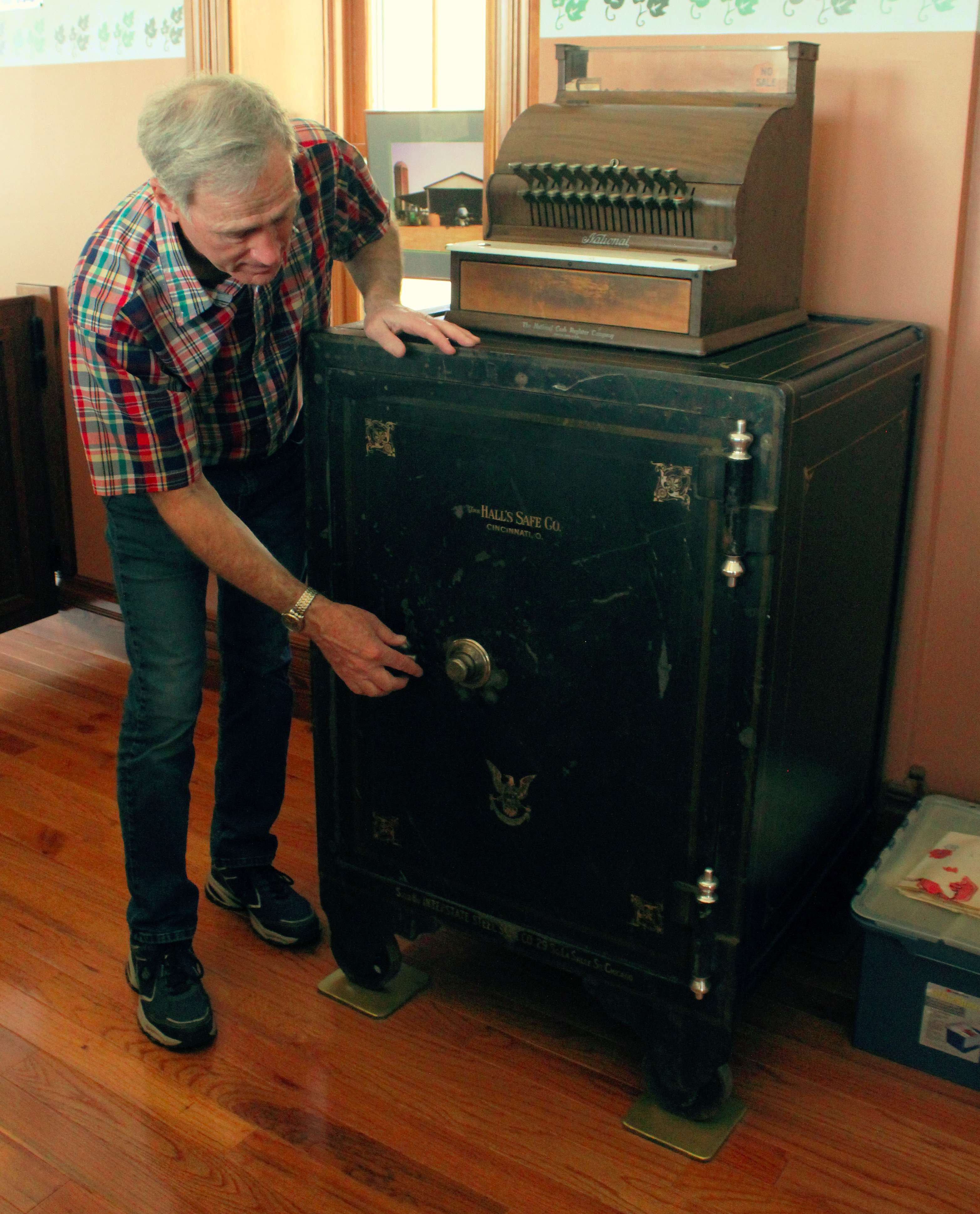 Tony Mahoney opens a safe on display at the Bankery. The museum also has copies of checks from the bank, which operated in Dorrance from 1905 to 1933. Photo by Cristina Janney / Hays Post<br>