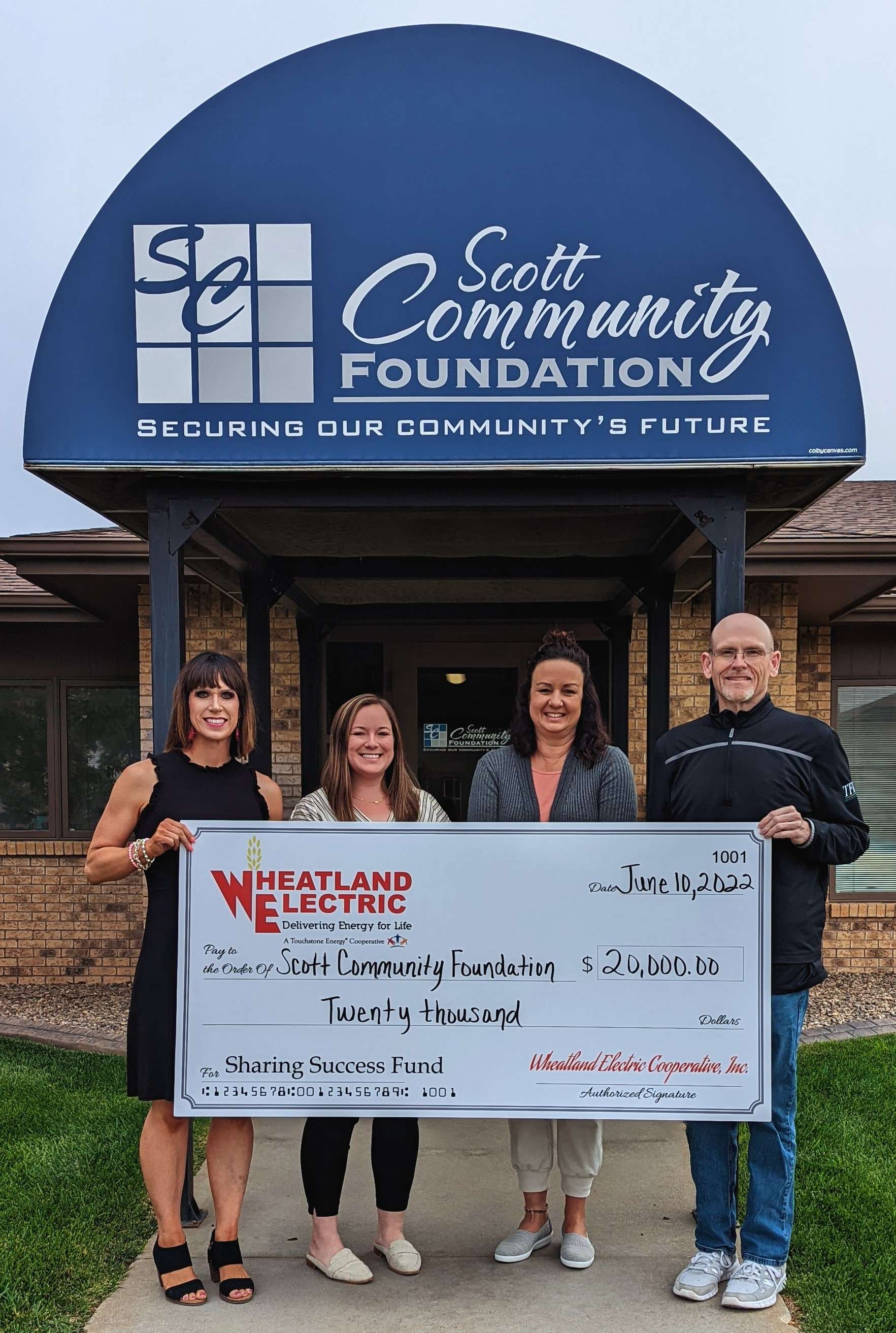 Alli Conine, director of member services and corporate communications (far left), presents a $20,000 check to representatives of the Scott Community Foundation on June 10, 2022. Community-based organizations operating in or serving Wheatland Electric’s service territory can apply for $1,000 in grant funds once per grant year.