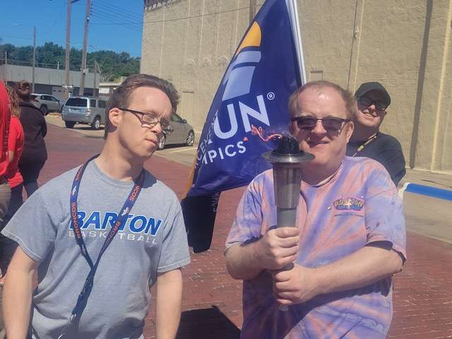 David Brack, left, and Robbie Davis, participate in the recent Special Olympics Torch Run. Donnie Lewis is in the background at right. Clients at Sunflower Diversified Services are returning to regular activities in this post-pandemic climate.