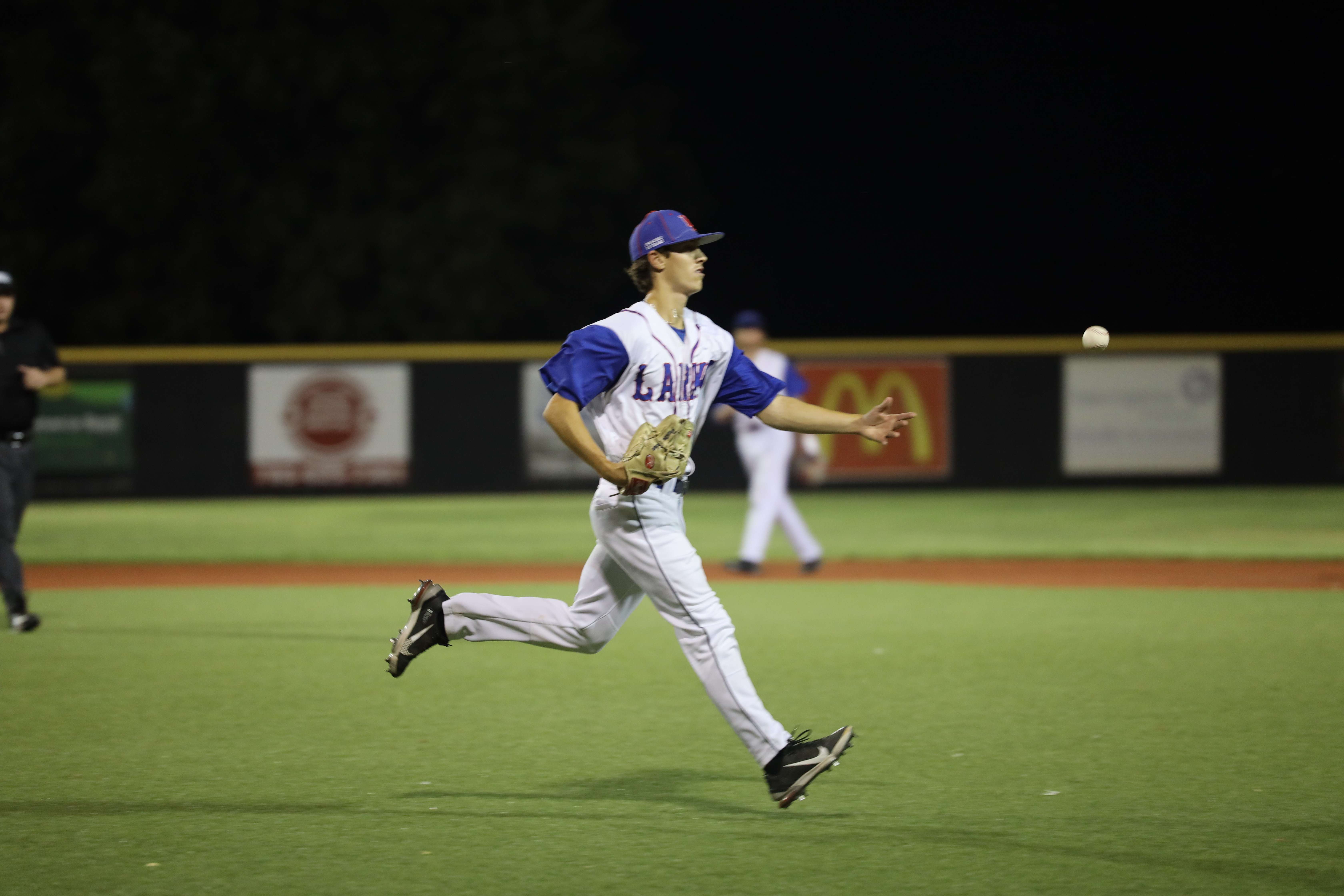 Larks pitcher tosses the ball to first Thursday vs the Liberal Bee Jays at Lark park (Cayden Sanders)